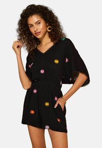 Schwarzer kurzer Jumpsuit mit V-Ausschnitt, verziert mit farbenfroher Sonnenstrahlstickerei, mit locker sitzenden Ärmeln und elastischer Taille.