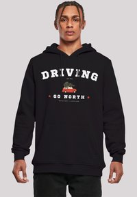 Black hoodie made of soft cotton blend. Features a large white print reading "DRIVING HOME" with red stars and a graphic of a car carrying a tree.