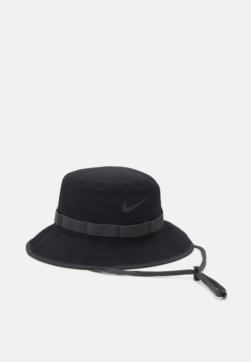 Sombrero de cubo negro hecho de tela con ala ancha. Presenta una banda texturizada y un pequeño logo de Nike en un tono más oscuro. Incluye un cordón ajustable.