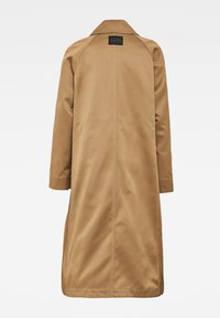 Jasnobrązowy płaszcz o gładkiej, teksturowanej powierzchni. Posiada klapowany kołnierz, długie rękawy oraz metkę z tyłu przy linii szyi.