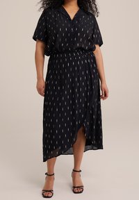 Musta midi-mekko, jossa on kauluspaita, lyhyet hihat ja kuvioitu hame, jossa on kapeat valkoiset ja kultaiset pystysuorat raidoitukset.