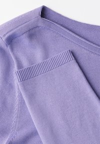 Suéter de punto lila claro con cuello redondo, puños acanalados y textura suave. Detalles de costura visibles a lo largo de los bordes.