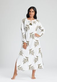 Vestido maxi blanco con un estampado de helechos en verde. Tela ligera con un corte holgado, mangas largas y un detalle de lazo en el frente.