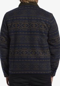 Giacca blu e marrone con motivo, dotata di un colletto peloso, che mostra design geometrici e un tessuto texturizzato. Vestibilità regolare con maniche lunghe.