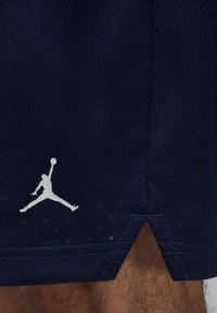 Pantalones cortos deportivos en color navy hechos de tejido perforado, con un logo Jumpman en blanco en el dobladillo y una ventilación lateral para mayor libertad de movimiento.