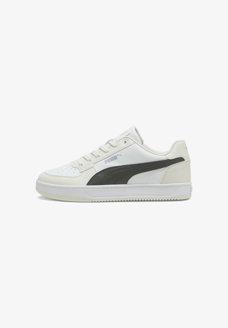 Zapatilla deportiva blanca de cuero con acentos en gris, cordones planos, caja de puntera perforada y suela de goma. Presenta el logo de Puma en el costado.