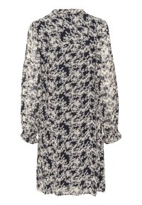 Robe longue à manches longues à motif floral noir et blanc avec manches transparentes et poignets froncés, vue de dos sur un fond blanc.