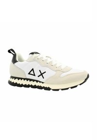 Sneaker con lacci con tomaia bianca, accenti in pelle scamosciata beige, tacco nero e un motivo a zigzag contrastante sulla suola. Presenta due loghi neri.