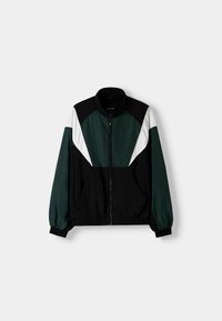 Svart och grön zip-up jacka med ståkrage, med vita och gröna färgblock accentuerade samt elastiska manschetter. Mjuk tygtouch.