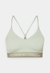 Svijetlozeleni sportski grudnjak s podesivim trakama, V-izrezom i širim elastičnim pojasom s bijelim "Nike Sportswear" logotipom.