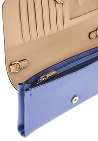 Pochette bleue texturée ouverte révélant un intérieur beige avec plusieurs emplacements pour cartes et un compartiment zippé.