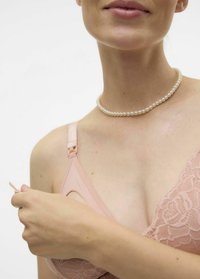 Svetlo roza čipkasta modrček z nastavitveno naramnicami in zaponko na kavljico; model se dotika naramnice, nosi kratek biserni ovratnik.