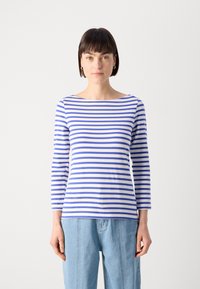 Stripet langermet skjorte med blå og hvite striper, båt-nakke, lett stoff og avslappet passform, kombinert med lyseblå jeans.