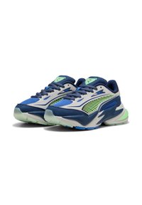Un paio di scarpe da ginnastica atletiche blu, bianche e verdi con dettagli in rete e pelle, suole spesse e lacci blu scuro su uno sfondo bianco.