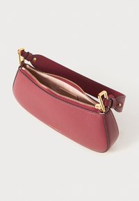 Pochette en cuir bordeaux avec une texture lisse, fermeture éclair dorée et forme rectangulaire. Intérieur doublé de tissu clair, comportant une petite étiquette de marque.