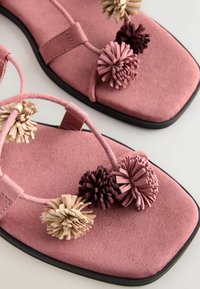 Ružové semišové sandále so štvorcovými špičkami, zdobené béžovými, tmavofialovými a ružovými strapcami z brmbolcov na tenkých remienkoch.