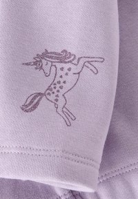 Tela púrpura con el contorno brillante de un unicornio encabritado, detallado con melena, cola y manchas en el cuerpo cerca del borde cosido.