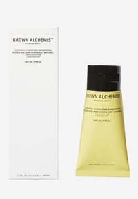 Naturlig återfuktande solkräm i en matt gul tub med svart kork, bredvid en vit låda. Textdetaljer inkluderar "Grown Alchemist" och SPF 30.