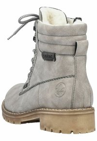 Bottine en suede gris avec un laçage à l'avant, un col rembourré et une semelle texturée. Présente des accents de marque et des coutures contrastées.