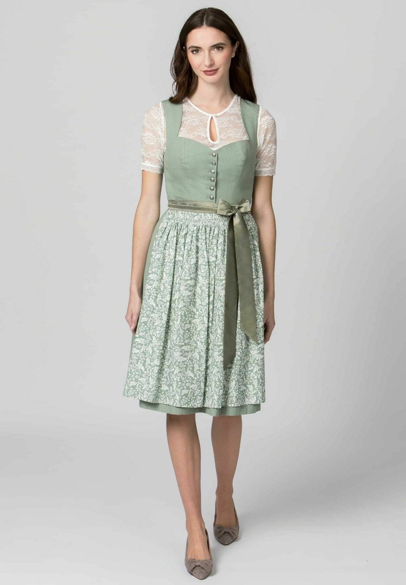 Light green dirndl with a fitted bodice, lace sleeves, button detail, and a floral-patterned skirt. Finished with a matching satin ribbon.