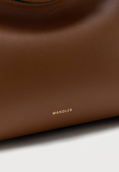 Barna bőrtáska sima textúrával, kis arany "WANDLER" logóval domborítva az alsó középső résznél.