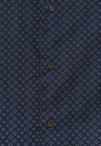 Dunkelblauer Stoff mit einem sich wiederholenden hellblauen Rautenmuster und drei braunen Knöpfen mit vier Löchern, die vertikal ausgerichtet sind.