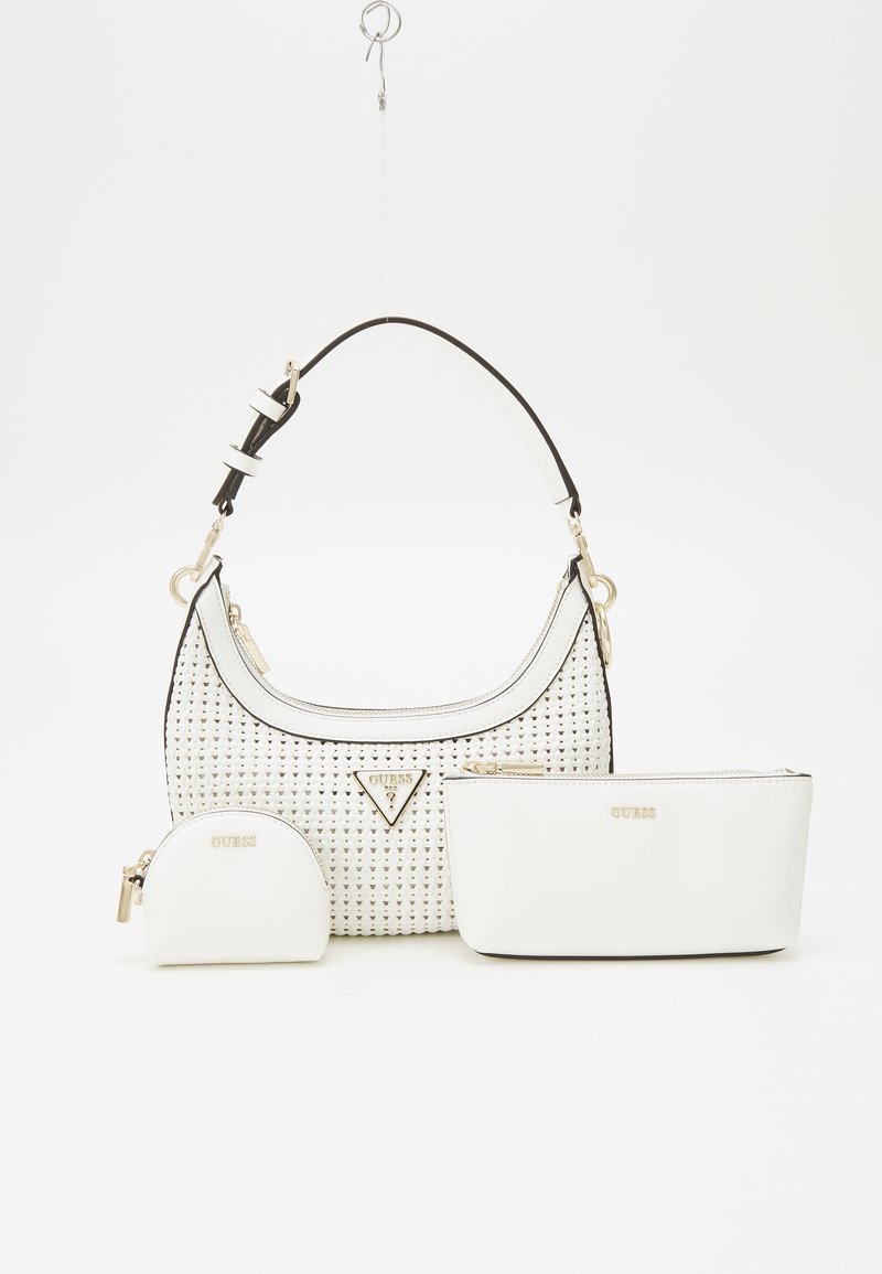 Sac bandoulière en tissu blanc avec bandoulière noire et accents dorés, accompagné de deux petites pochettes blanches assorties à fermeture éclair, embossées du nom de la marque.