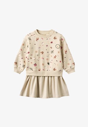 Robe longue à manches longues beige avec des motifs sur le thème de Noël, comprenant des rennes, des maisons en pain d'épice, des cannes de bonbon, des couronnes et des cadeaux, avec une jupe plissée.