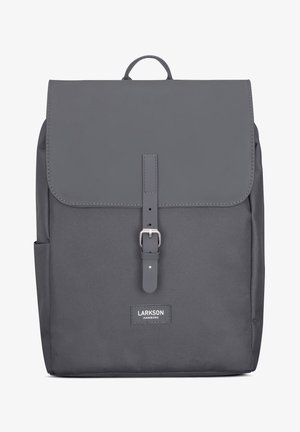 Gray backpack made of durable fabric with a flap closure, front buckle, and logo tag. Features a top handle and side pockets.