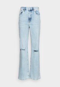 Jeans de cintura alta em azul claro com detalhes desgastados nos joelhos e um design de perna flared. Feitos de tecido denim com uma textura suave.