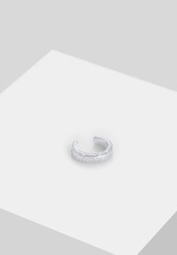 Sølvtekstureret ring med et åbent design, der har en let uregelmæssig overflade og en minimalistisk æstetik.