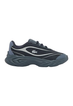 Dunkelgrauer und schwarzer Sportschuh mit dicker, strukturierter Sohle, Wellenmustern und einem Krokodil-Logo an der Seite.