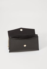 Portefeuille en cuir synthétique noir avec une texture brillante, doté d'une fermeture à pression dorée, de détails en chaîne et de deux compartiments intérieurs.