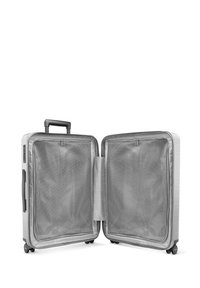 Valise rigide avec une finition argent métallique, deux compartiments, des séparateurs en maille et une poignée rétractable ; équipée de roulettes pour plus de mobilité.