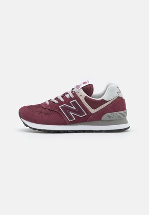 Sneaker bordeaux con accenti grigi, materiali in camoscio e mesh, punta tonda, suola in gomma spessa e logo sul lato. Lacci piatti grigi.