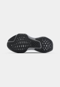 Semelle extérieure en caoutchouc noir et gris d'une chaussure de course avec des motifs pour la traction et la flexibilité.