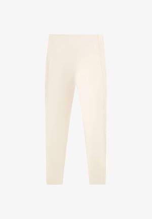 Magas derekú, teljes hosszúságú krémszínű leggings sima, letisztult kialakítással, varrások vagy minták nélkül.