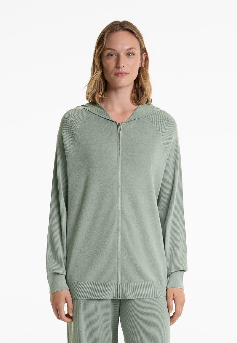 Ljusgrön ribbad zip-up hoodie med huva och långa ärmar. Tillverkad av strukturerad tyg, med en avslappnad passform och dragkedjestängning.