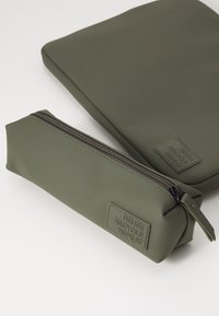 Green silicone laptop sleeve and pencil case with a smooth texture. Both feature a zipper and a label that reads "Reuse, Recycle, Repeat."