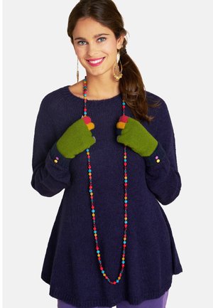 Marineblauer gestrickter Pullover mit lockerem Schnitt, grüne fingerlose Handschuhe mit bunten Spitzen und eine mehrfarbige Perlenkette.