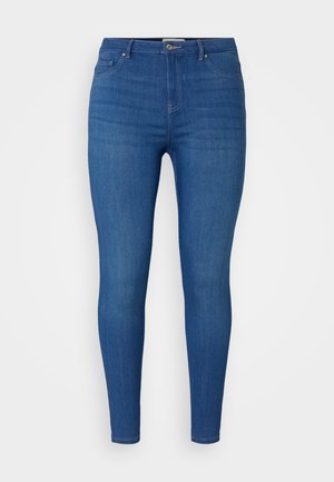 Jeans skinny de mezclilla azul con una cintura de media altura, diseño de cinco bolsillos y un ligero desgaste. Costuras clásicas y detalle de botón metálico.