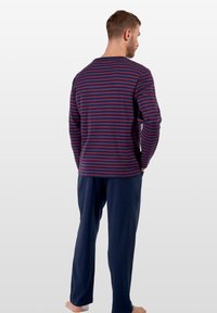 Gestreepte lange mouwen top in marineblauw en bordeauxrood met een ronde hals, gecombineerd met effen marineblauwe broeken in een relaxte pasvorm en zachte stof.