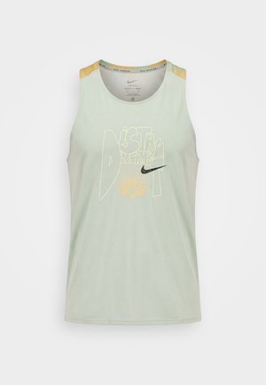 Heleroheline varrukateta Nike jooksutopp kollase graafilise tekstiga „DISTANT DREAMS“ ja musta Nike märgiga ees.