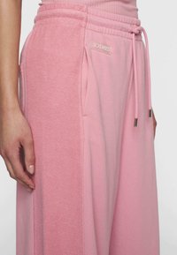 Roze sweatpants van een textuurstof, met een verstelbare tailleband, zijzakken en een logo patch. Soepele afwerking en een ontspannen pasvorm.