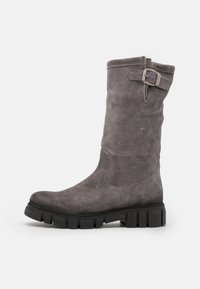 Bota alta hasta la rodilla de ante gris con un detalle de hebilla lateral, suela gruesa negra, punta ligeramente redondeada y textura suave.