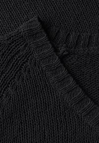 Tessuto nero a maglia caratterizzato da una texture a coste e da motivi variabili, con una finitura morbida e leggermente pelosa in dettaglio ravvicinato.