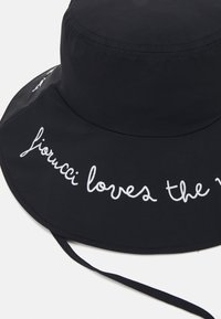 Fekete vödörkalap széles karimával, fehér hímzett szöveggel: "fiorucci loves the world". Állítható állszíj tartozik hozzá.