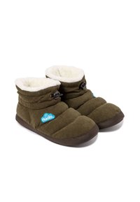 Zapatillas de terciopelo verde con un suave forro blanco, que cuentan con un diseño plegable, botones negros y una suela de goma marrón.