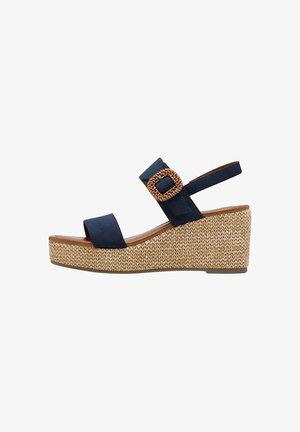 Laivaston siniset suede-wedge-sandaalit, joissa on kudottu jute-alusta ja pyöreä kudottu solkiyksityiskohta. Ominaisuuksiin kuuluu nilkkaremmitys ja leveä etuosa.