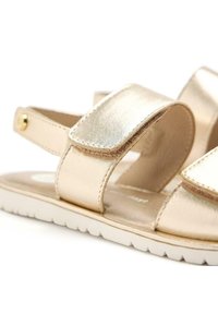 Sandalias metálicas doradas con dos correas anchas y un acabado texturizado. Con una suela acolchada y un diseño ligero.